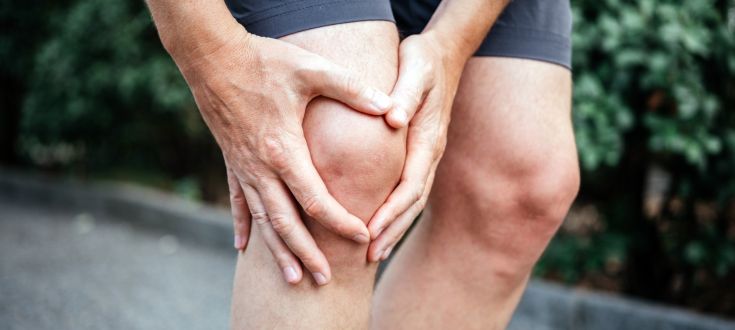 menisco rotto, persona si regge il ginocchio con le mani